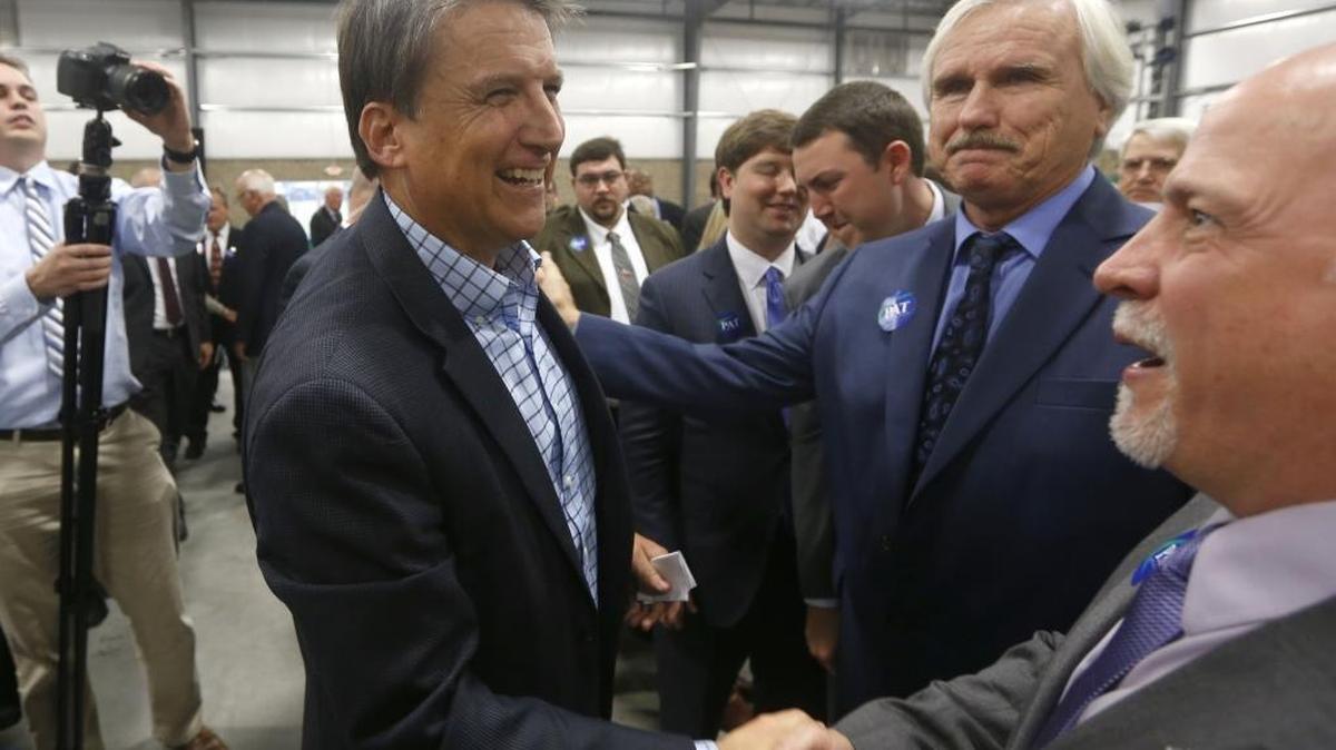 Governor Pat McCrory greets supporters Mark Estep, center, and Robert Allen, right, both of Charlotte, after launching his re-election campaign during an event at Salem One in Kernersville, N.C., Wednesday, Dec. 2, 2015.
