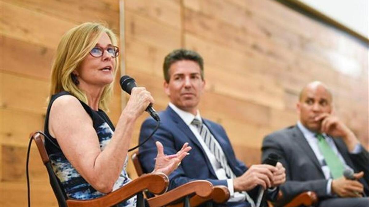 Kathleen Parker, left, of the Washington Post speaks during the launch of a book by Wayne Pacelle, President and CEO of The Humane Society of the United States, center, on Monday at Sidwell Friends in Washington. Senator Cory Booker of New Jersey is at right.