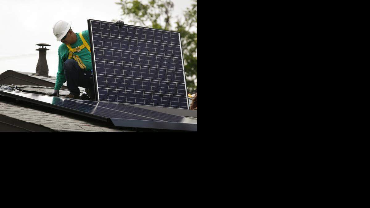 
2014 file – A SolarCity Corp. employee installs a solar panel on the roof of a home in Los Angeles. A new North Carolina bill would allow independent energy developers to sell electricity directly to homeowners and businesses.
