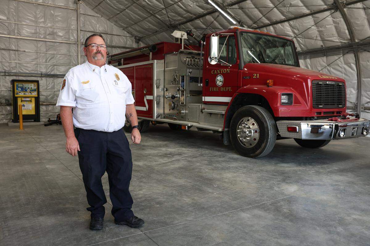 Canton Fire Chief Kevin Wheeler stands inside a makeshift garage that houses the department’s fire trucks, which is uphill from a triple-wide trailer on the gravel campus where the fire department, police department and town hall are all located. Previous to being in a triple-wide, the fire department was operating out of a camper that four firemen at a time would occupy for their 48-hour shifts. 