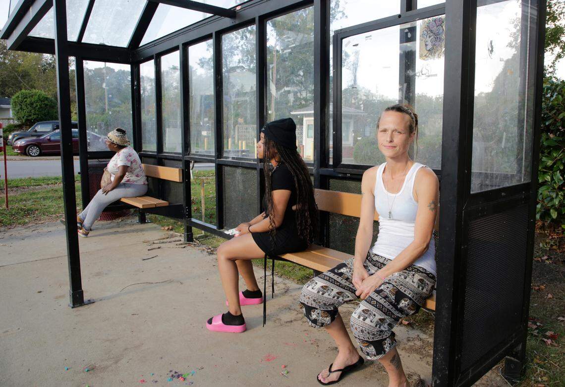 Sarah Bollo, right, sits at the bus stop Friday at Oct. 4, 2024 at Hillcrest Apartments in Asheville, N.C.
