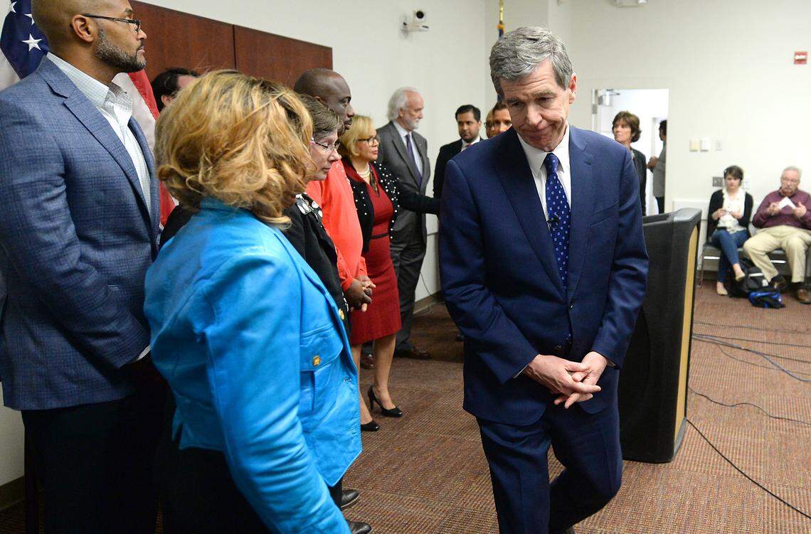 North Carolina Governor Roy Cooper, right, exits a press conference at the Charlotte-Mecklenburg Government Center on Wednesday, March 11, 2020. Cooper said that North Carolina has not yet received all of the novel coronavirus testing supplies it needs from the CDC to continue testing in the way it wants.