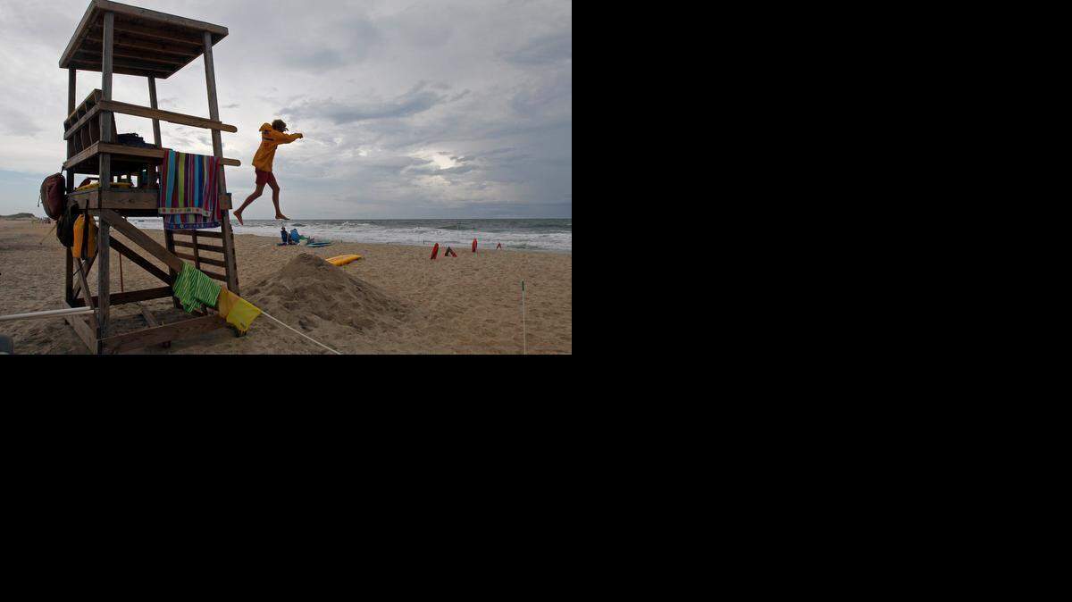 
A lifeguard stands along Cape Hatteras National Seashore in Buxton: In a pilot program in Chile, a drone goes out to a swimmer in distress, drops a floatation device, and then hovers, while a lifeguard swims to the scene. 
