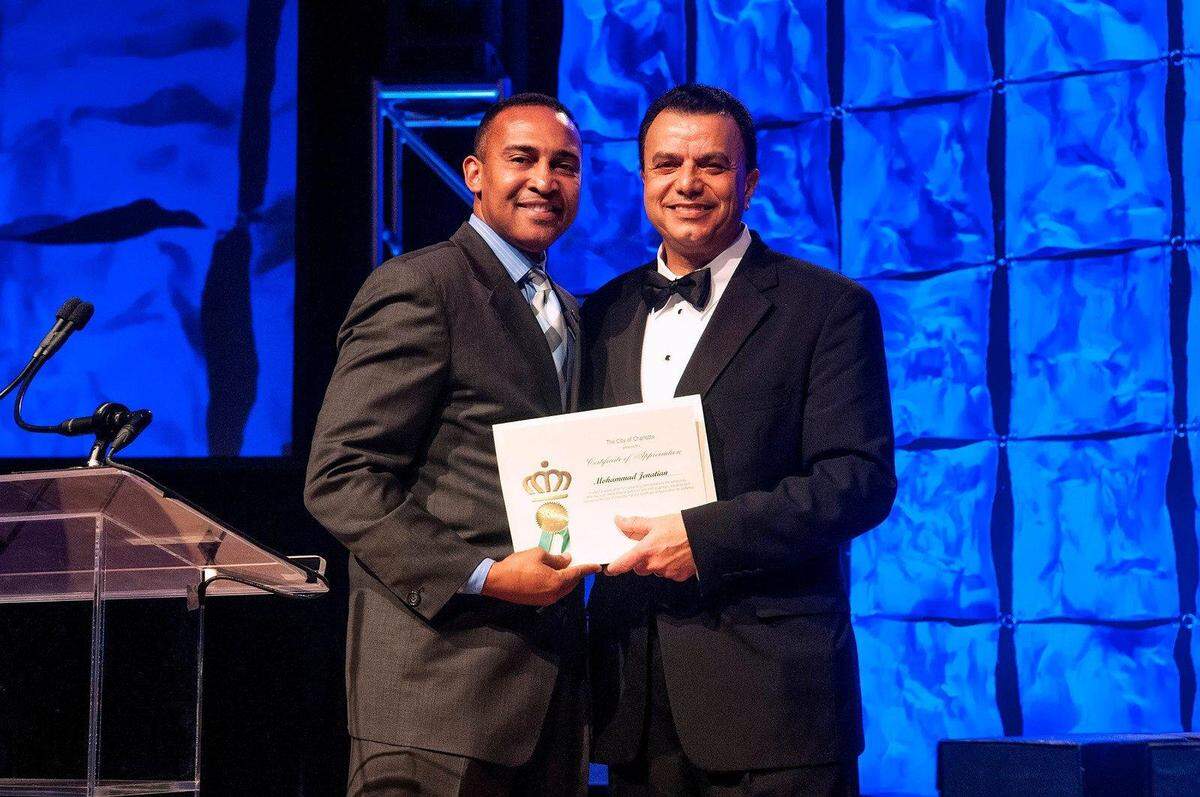 Charlotte mayor Patrick Cannon (left) presents Greater Charlotte Hospitality and Toursim Alliance president Mohammad Jenatian with a certificate of appreciation from the city of Charlotte at the HTA’s annual dinner February 20, 2014 in the Crown Ballroom of the Charlotte Convention Center. MAC330