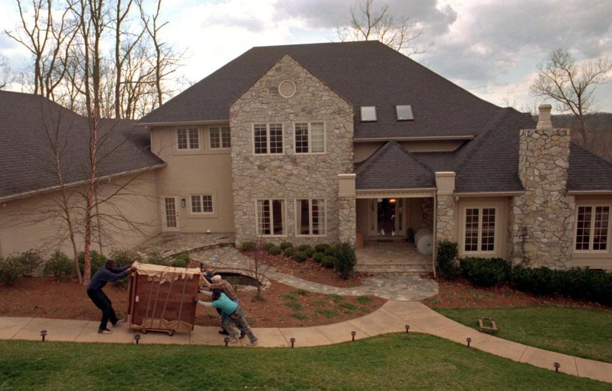 Furniture movers push a large wardrobe at the home of Steven and Michelle Chambers.