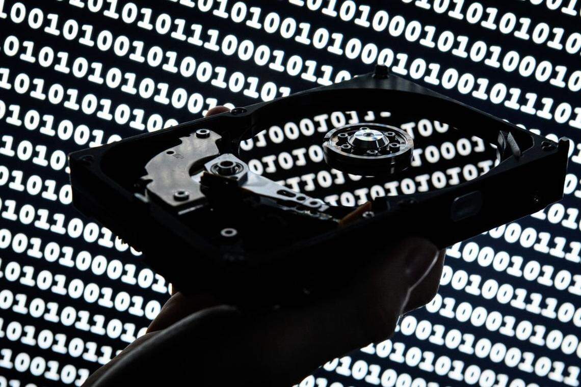 LONDON, ENGLAND - AUGUST 09: In this photo illustration, a hard drive is seen in the light of a projection of binary data on August 09, 2017 in London, England. (Photo by Leon Neal/Getty Images)