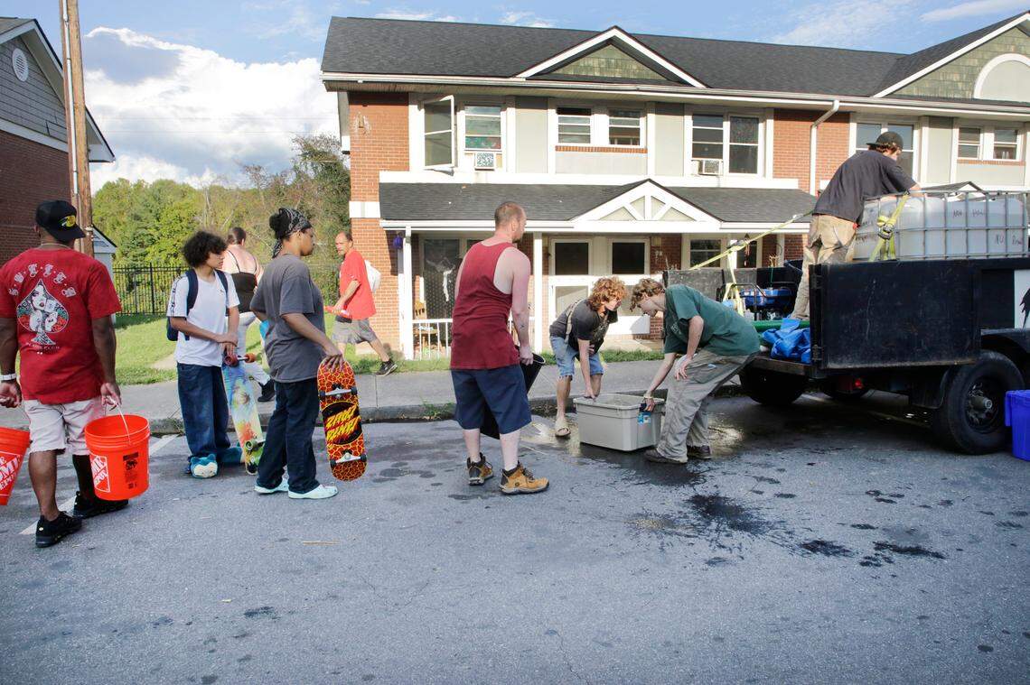 Residents of Hillcrest Apartments wait to get non-potable water Friday, Oct. 4, 2024 in Asheville, N.C.