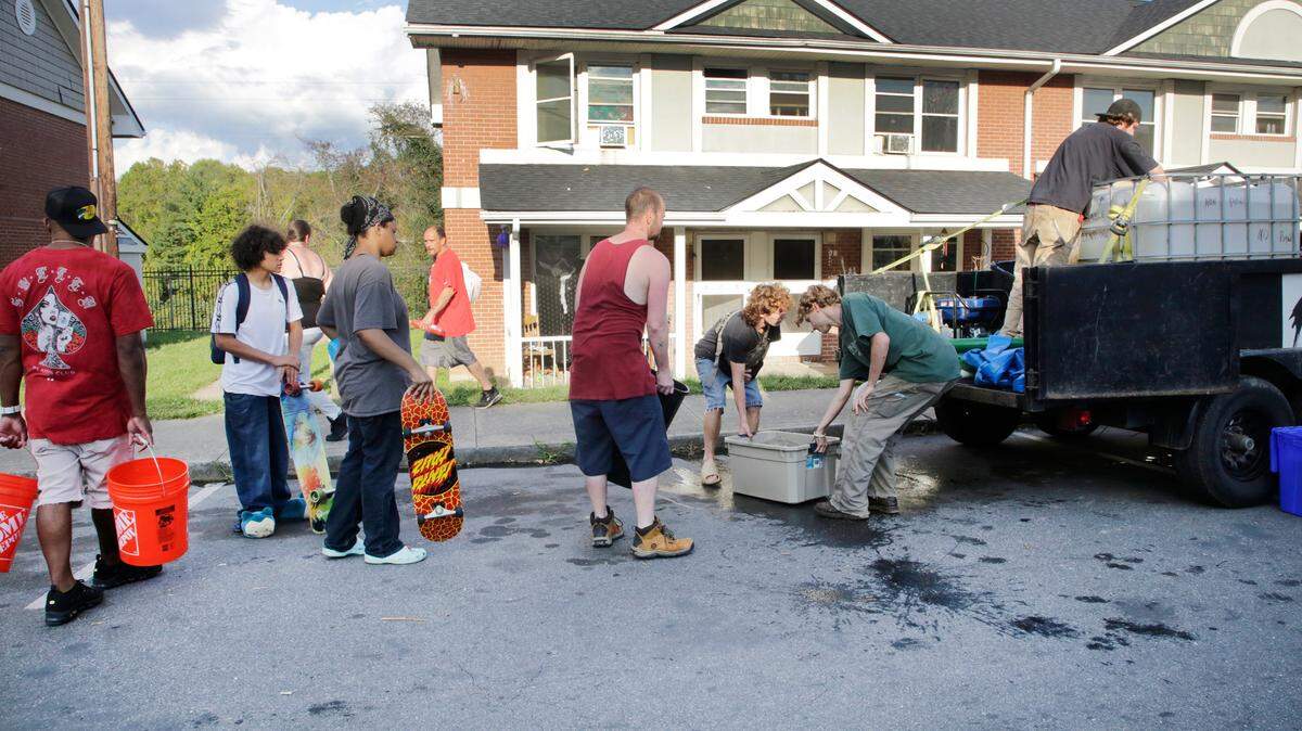 Residents of Hillcrest Apartments wait to get non-potable water Friday, Oct. 4, 2024 in Asheville, N.C.