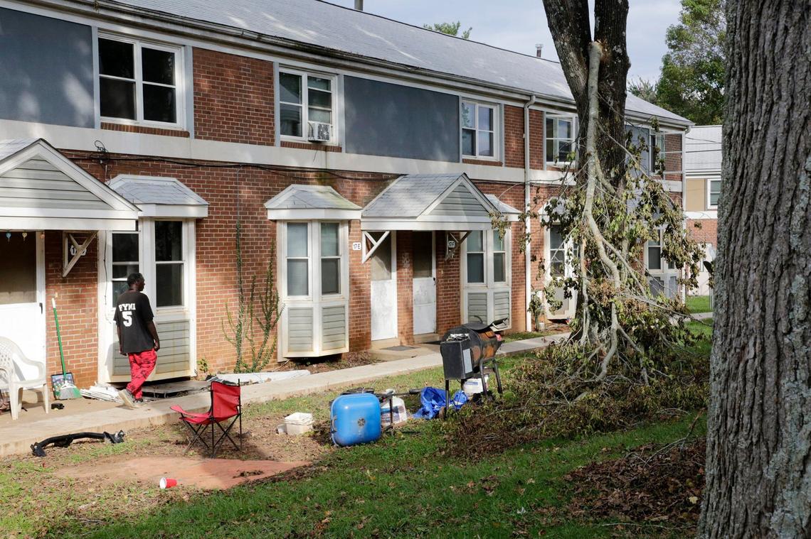 A resident of the Pisgah View apartments walks to his home near a fallen tree branch Thursday, Oct. 3, 2024 in Asheville, N.C.