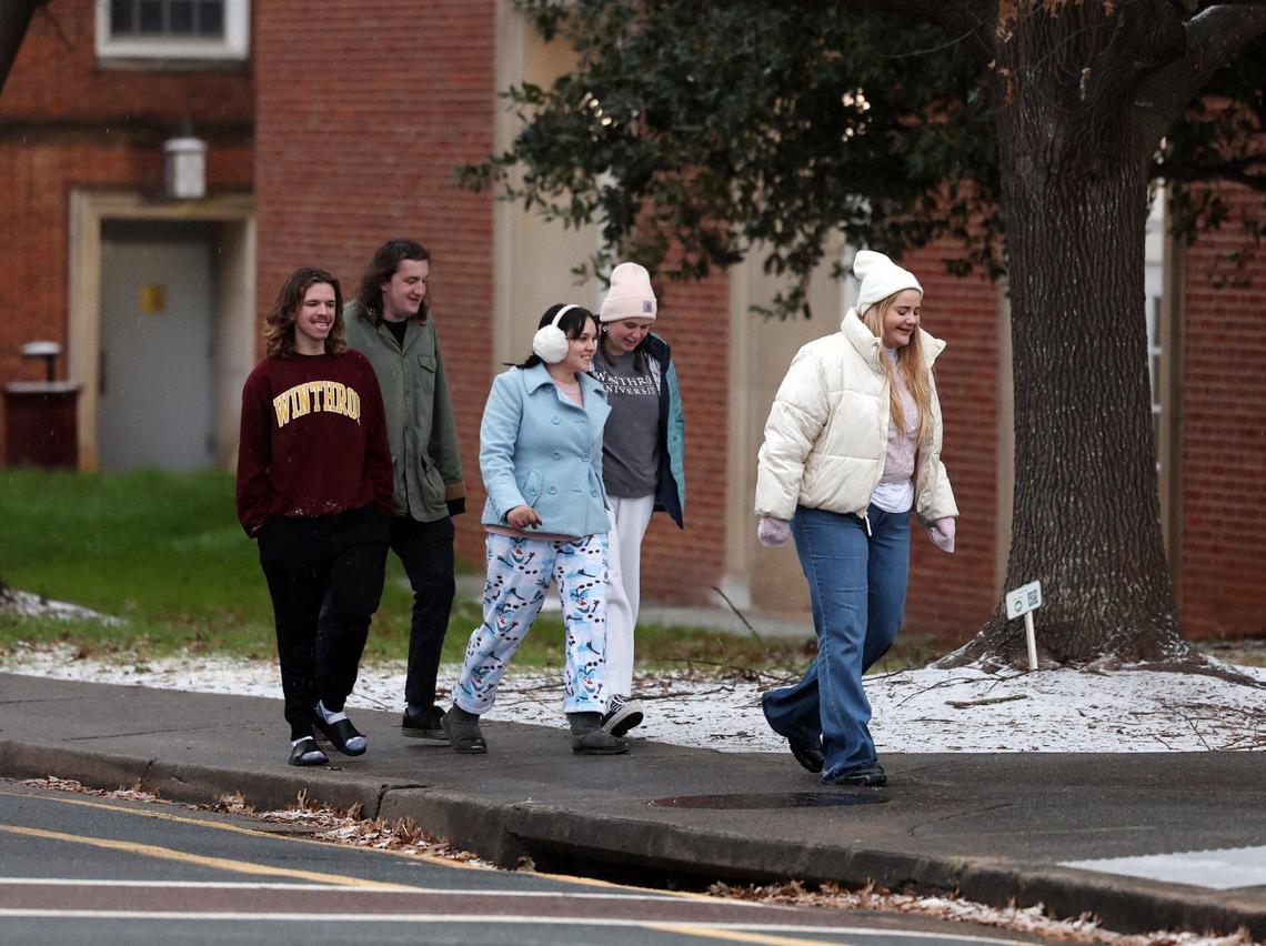 Winthrop University students walk on campus near freshly-fallen snow and sleet