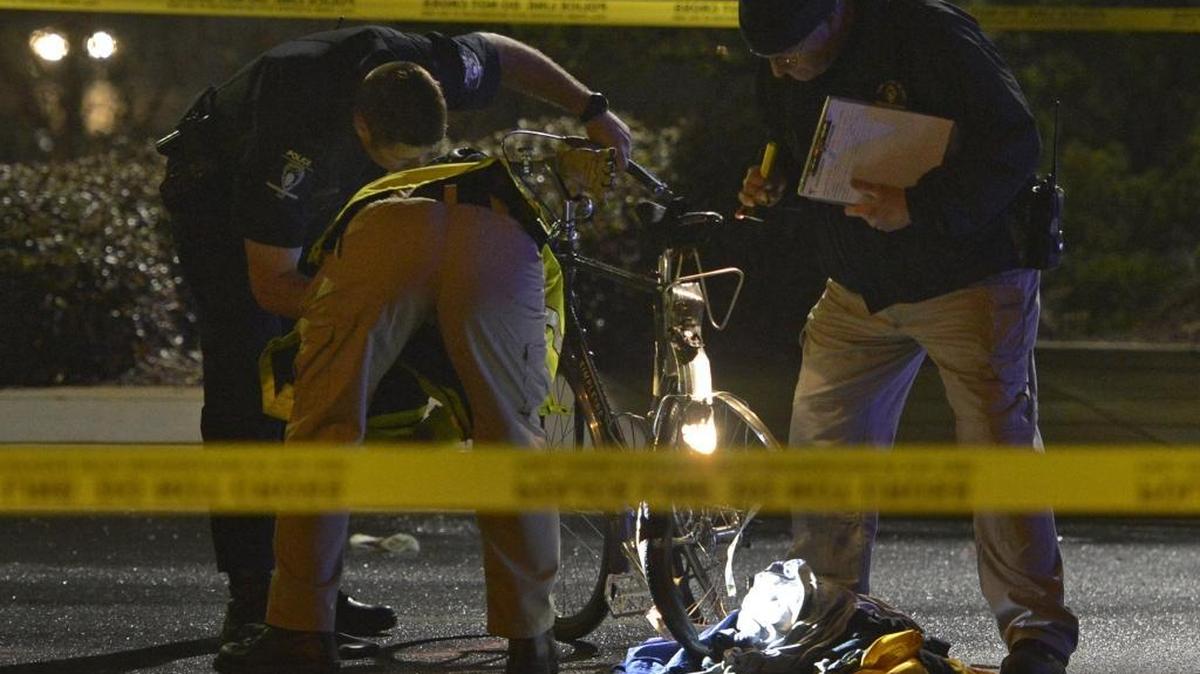 
Police examine evidence after a bicyclist was hit by a vehicle near Eastland Mall in March.
