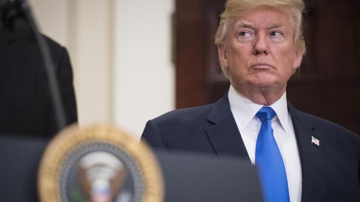 President Trump listens during the unveiling of legislation that would place new limits on legal immigration.