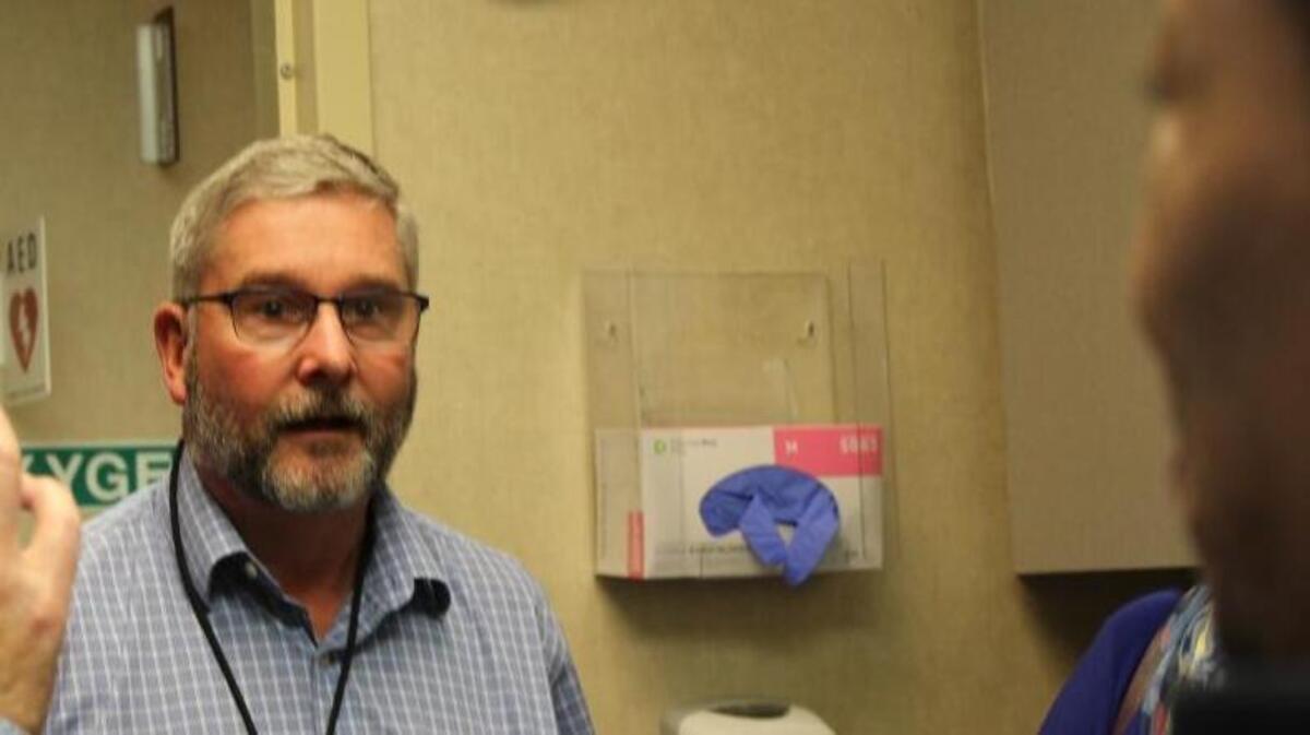 Dr. Mark Parker is surprised by a visit Wednesday from former Charlotte Hornet Muggsy Bogues.