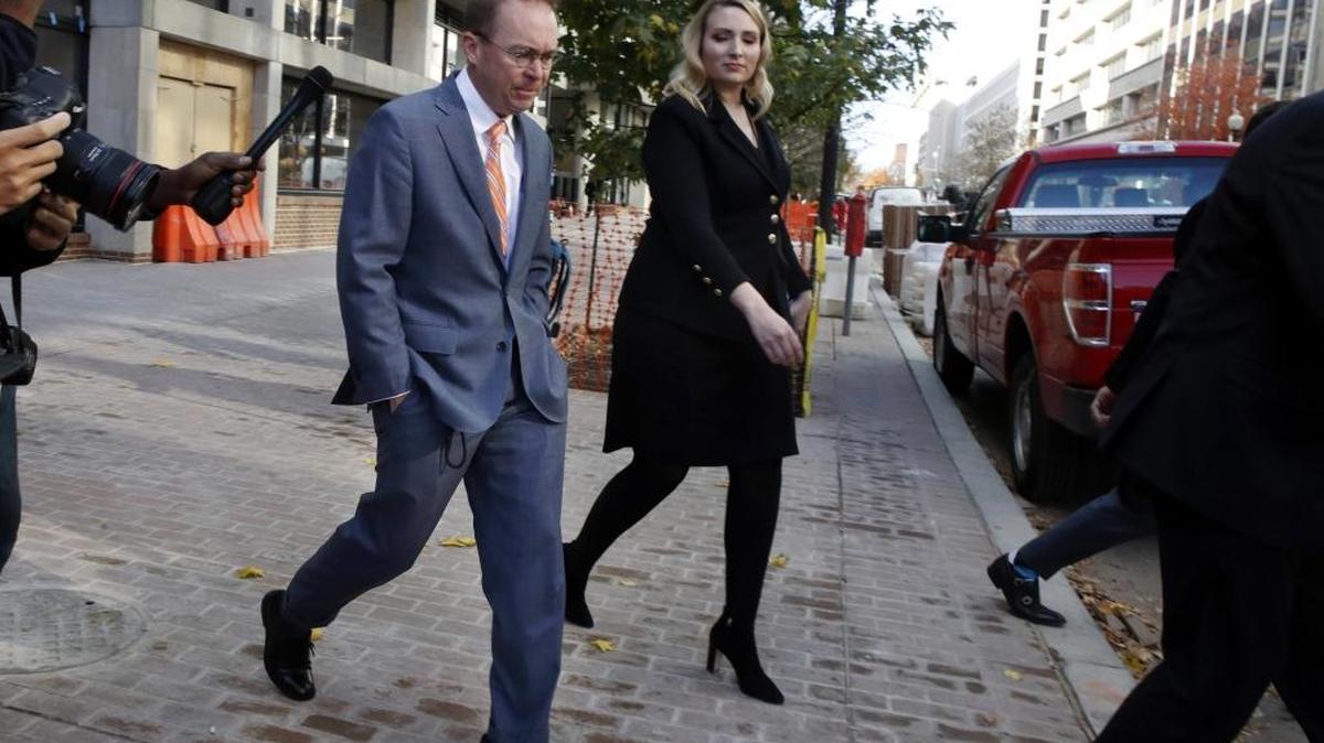 Mick Mulvaney, left, leaves the Consumer Financial Protection Bureau in Washington, Monday.