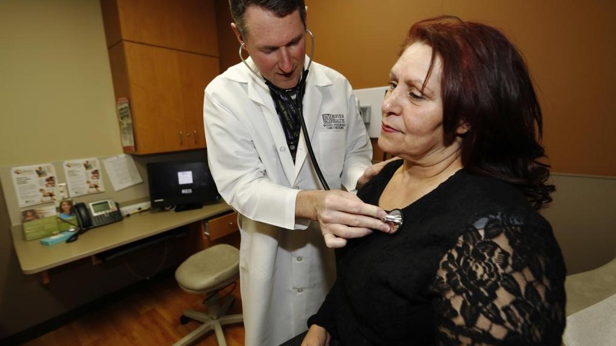 Dr. Michael Russum checks patient Ruby Giron at a primary care clinic in Denver. The new GOP health care proposal could roll back Medicaid expansion and take away subsidies to help pay for insurance.