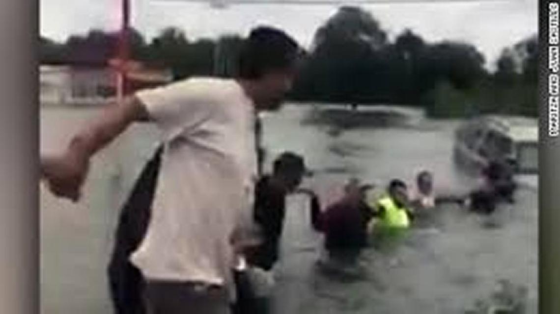 People form a human chain on Interstate 10 in Houston to rescue a man in floodwaters Tuesday.