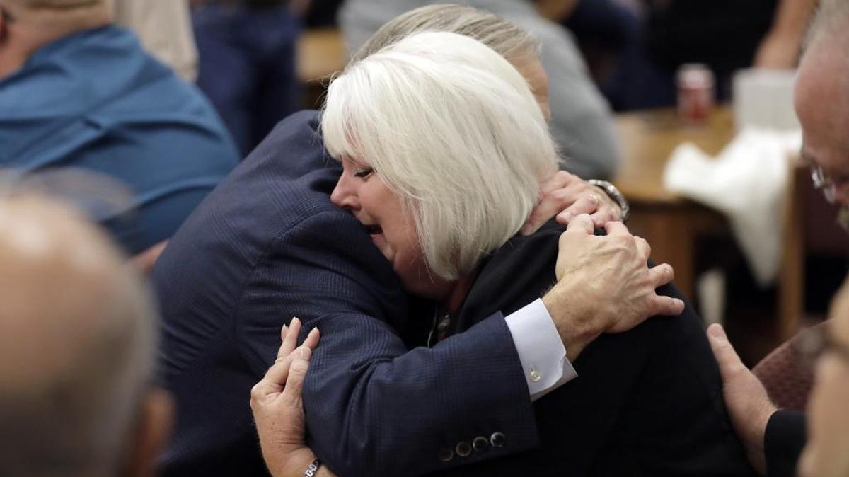 Texas Gov. Greg Abbott hugs a woman as he visits with family and victims of the Sutherland Springs shooting Wednesday.