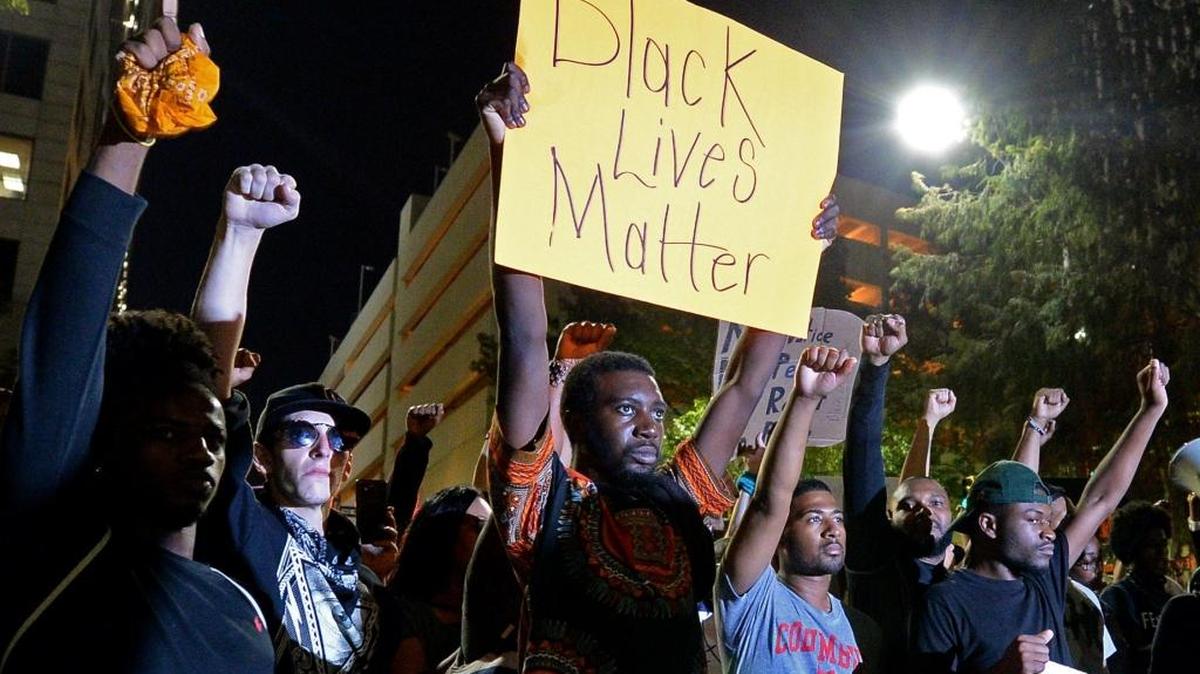 Protesters stand in unity as they prepare to march throughout the city of Charlotte on Friday, Sept. 23.