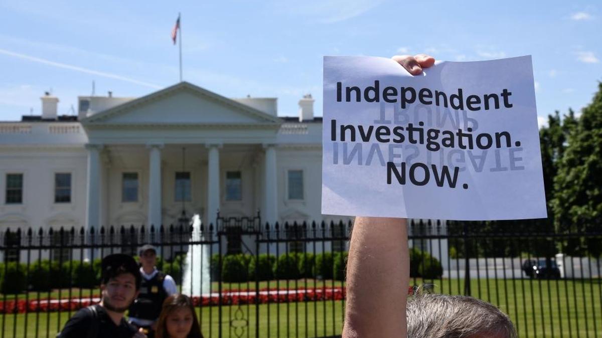 People protest Wednesday in front of the White House to demand the investigation of President Donald Trump after he fired FBI Director James Comey.