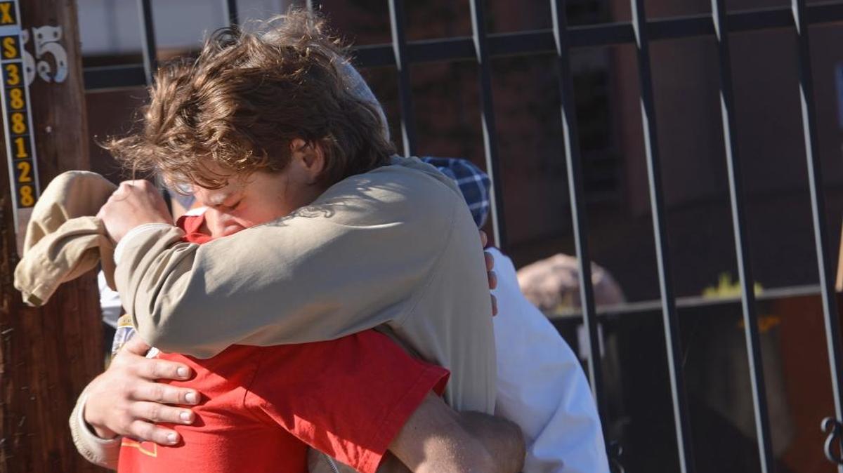 
Two people embrace Friday outside a Northern Arizona University student dormitory after an early morning confrontation between two groups of students escalated into gunfire. 
