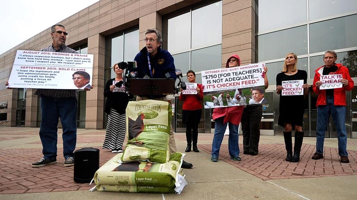 Kevin Strawn, a teacher at East Mecklenburg High School, and other educators brought bags of chicken feed to Gov. Pat McCrory’s Charlotte office to tell him he can keep his “chicken feed” $750 bonuses.