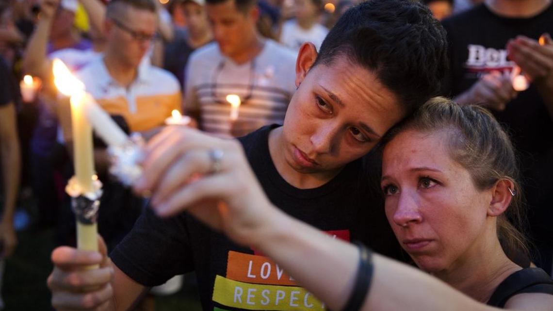 Jennifer, right, and Mary Ware light candles during an Orlando vigil for the victims of Sunday’s mass shooting.