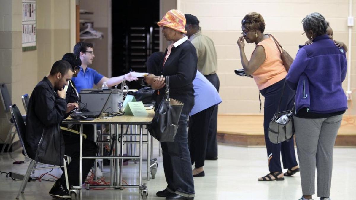 Precinct workers in Durham verify IDs and hand out ballots to early afternoon voters Tuesday.