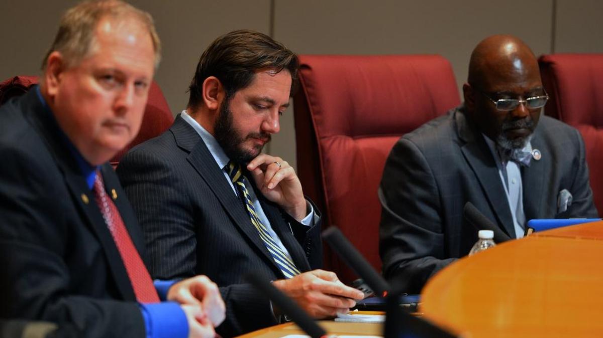 Republican commissioner Matthew Ridenhour, center, was the only commissioner to oppose the pay hike. Republican Bill James, left, and Democrat George Dunlap, right, were among those backing the idea.