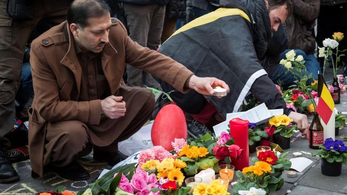 A man lights candles at a makeshift memorial in front of the stock exchange in Brussels.