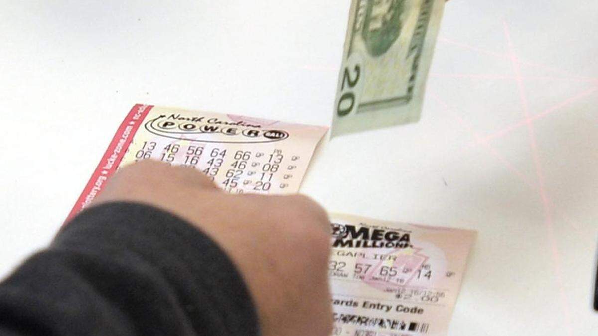 A customer at the Highland Creek BP in Charlotte purchases a ticket for the upcoming Powerball drawing Tuesday.