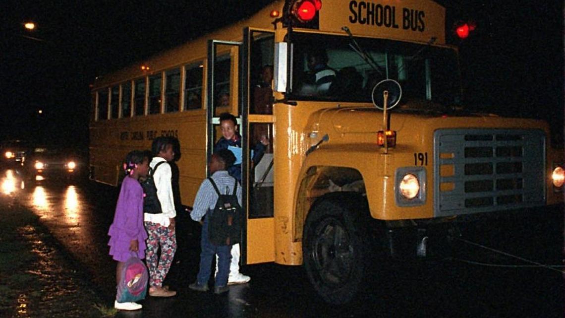 In 1995, Sharon Elementary students board their bus while it’s still dark off Steele Creek Road. Their parents were concerned about busing and wanted a neighborhood school.