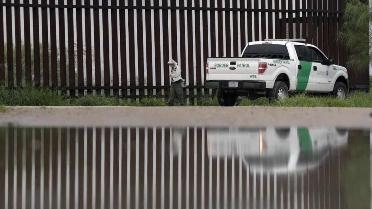 A U.S. Customs and Border Patrol agent passes along a section of the border wall in Hidago, Texas.