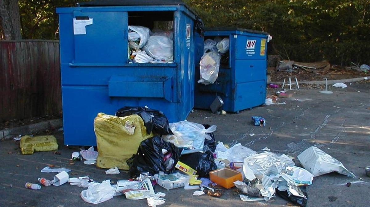 A trash bin overflowing with garbage.
