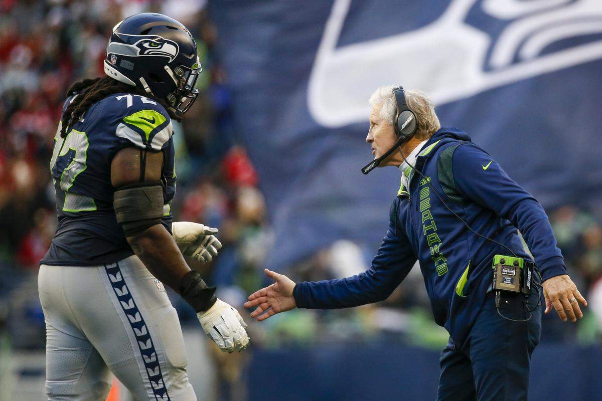 Seattle Seahawks head coach Pete Carroll celebrates with players after an extra point against the San Francisco 49ers during the third quarter at Lumen Field. 