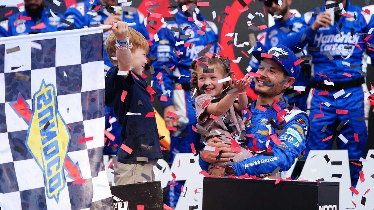 Apr 16, 2023; Martinsville, Virginia, USA; NASCAR Cup Series driver Kyle Larson (5) celebrates in victory lane with his children Owen Larson and Audrey Layne Larson after winning the NOCO 400 at Martinsville Speedway. Mandatory Credit: John David Mercer-USA TODAY Sports