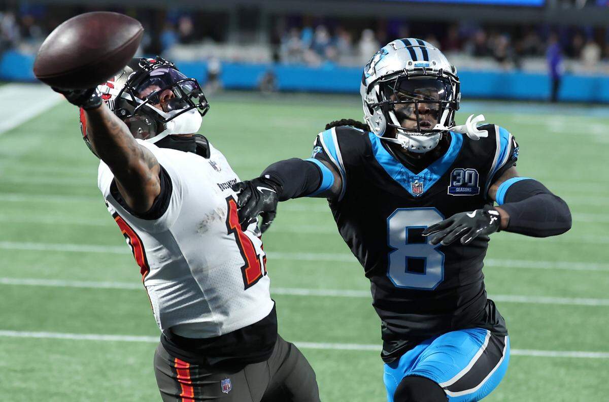 Carolina Panthers cornerback Jaycee Horn, right, applies defensive pressure on Tampa Bay Buccaneers wide receiver Sterling Shepard, left, during action at Bank of America Stadium in Charlotte, NC on Sunday, December 1, 2024. The Buccaneers defeated the Panthers in overtime 26-23.