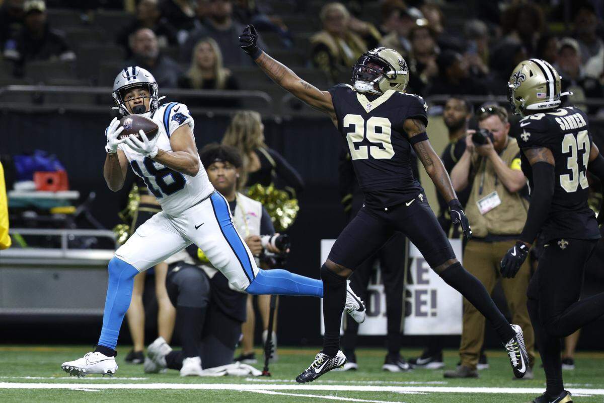 Jalen Coker (18) of the Carolina Panthers catches a touchdown pass against Quincy Riley of the New Orleans Saints during Sunday’s third quarter at Caesars Superdome.