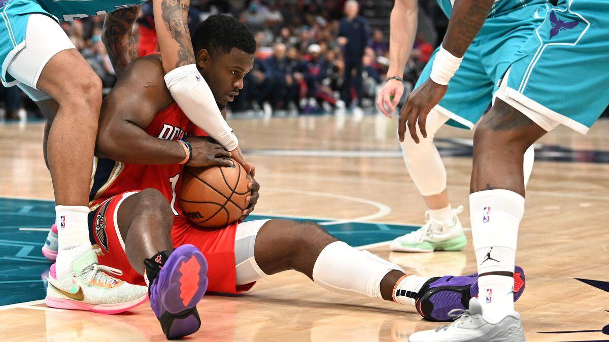 New Orleans Pelicans forward Zion Williamson, center, fights to maintain control of a loose ball as the Charlotte Hornets defense collapses on him during first half action on Friday, October 21, 2022 at Spectrum Center in Charlotte, NC.