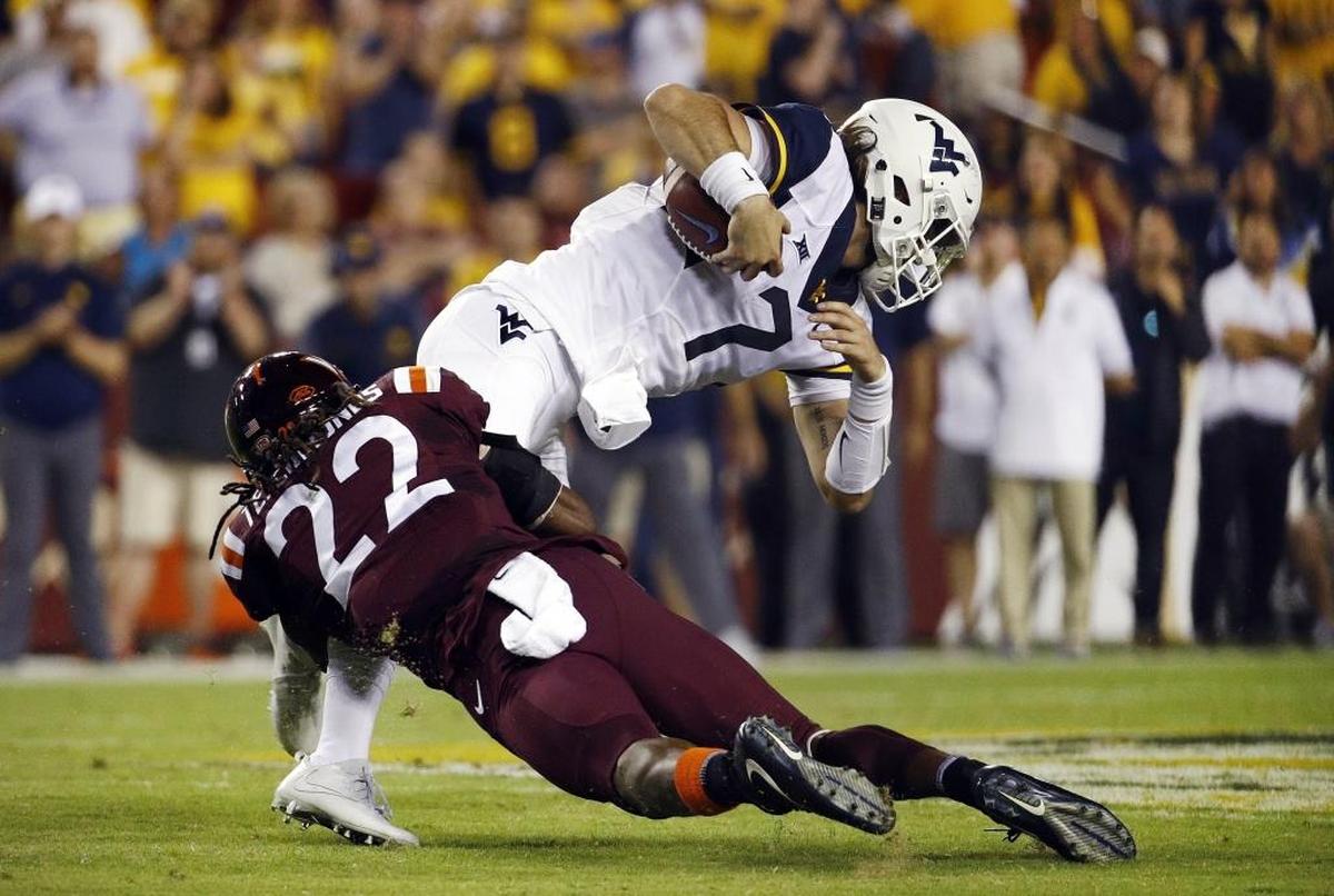 West Virginia quarterback Will Grier, top, is tackled by Virginia Tech safety Terrell Edmunds as he rushes the ball in the first half of an NCAA college football game in Landover, Md., Sunday, Sept. 3, 2017. (AP Photo/Patrick Semansky)