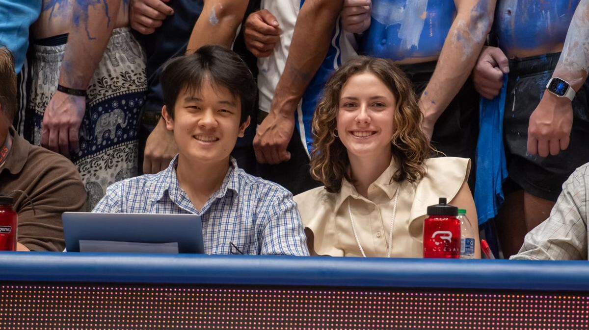Shelby Swanson, right, sits courtside at Cameron Indoor Stadium to cover a UNC-Duke men’s basketball matchup on March 9, 2024. The Daily Tar Heel sports editor is joined by her colleague, Daniel Wei.