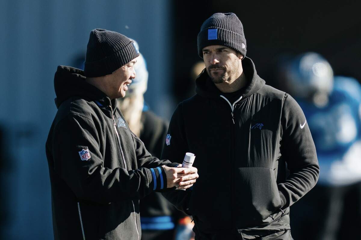 George Li, left, and Carolina Panthers head coach Dave Canales have an on-field discussion during practice. Li is the team’s game management coordinator and a close collaborator with Canales, the team’s offensive play caller.