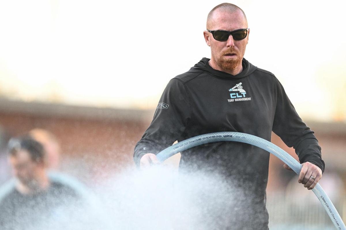 Charlotte Knights head groundskeeper Matt Parrott waters the field prior a Minor League Baseball game between the Charlotte Knights and Gwinnett Stripers at Truist Field, Friday, March 28, 2025, in Charlotte, N.C. (Charlotte Observer/Matt Kelley)