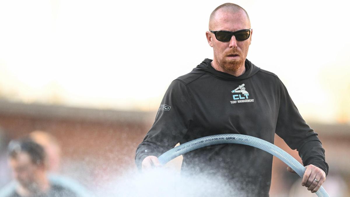 Charlotte Knights head groundskeeper Matt Parrott waters the field prior a Minor League Baseball game between the Charlotte Knights and Gwinnett Stripers at Truist Field, Friday, March 28, 2025, in Charlotte, N.C. (Charlotte Observer/Matt Kelley)