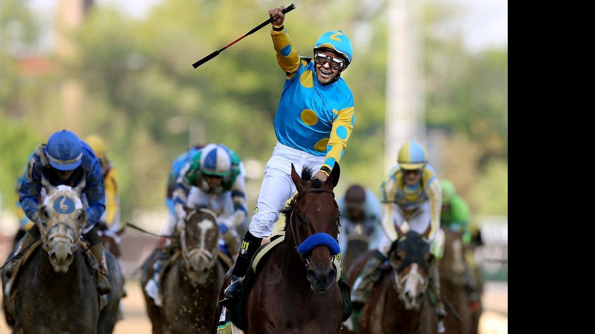 
Jockey Victor Espinoza celebrates as he guides American Pharoah #18 after crossing the finish line to win the 141st running of the Kentucky Derby at Churchill Downs on May 2, 2015 in Louisville, Kentucky.
