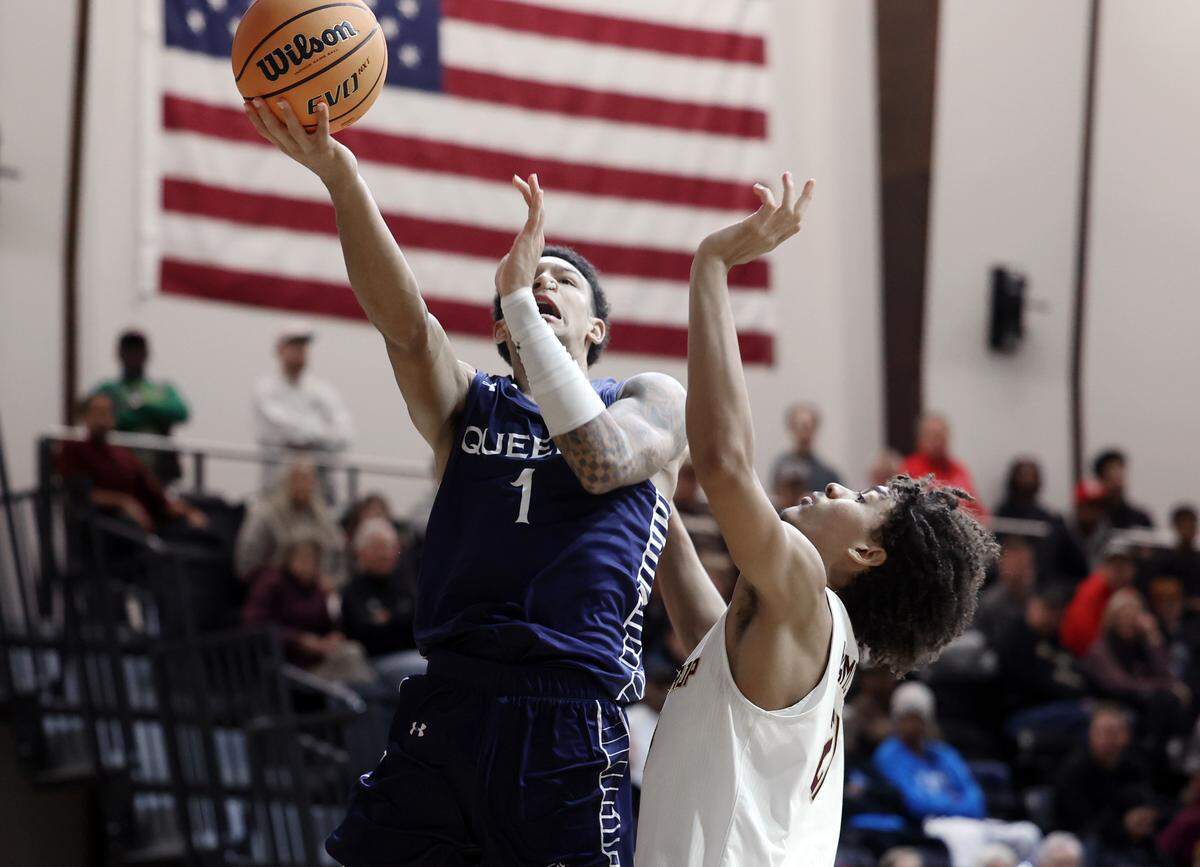 Queens University's Nasir Mann puts up the shot around Winthrop University's Tai Hamilton on Monday morning at the Rock HIll Sports and Event Center.