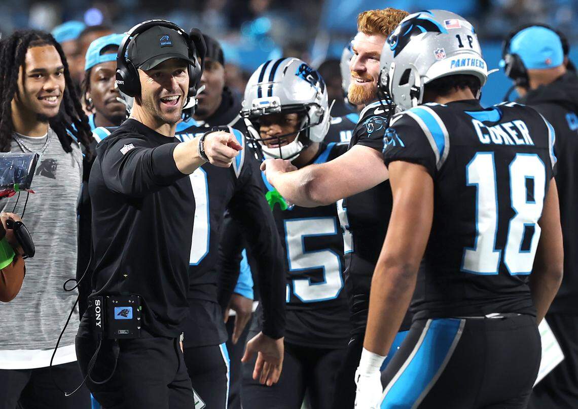 Carolina Panthers head coach Dave Canales, left, points to wide receiver Jalen Coker, right, following a touchdown during action against the Los Angeles Rams at Bank of America Stadium on Saturday, January 10, 2026.