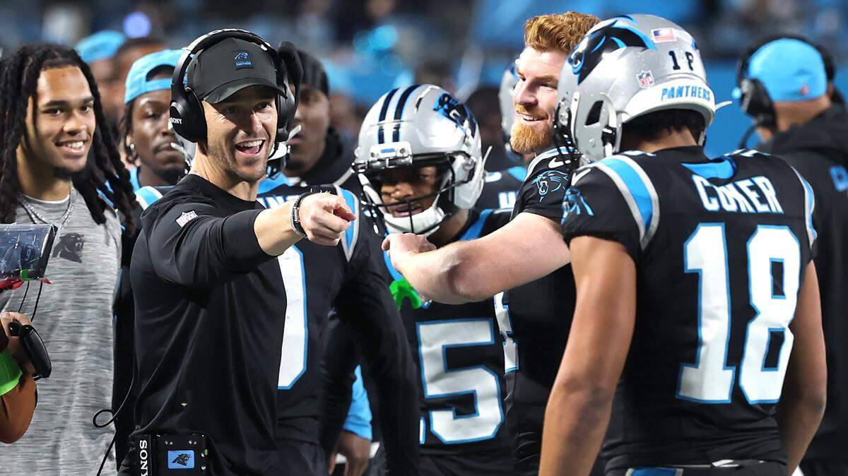 Carolina Panthers head coach Dave Canales, left, points to wide receiver Jalen Coker, right, following a touchdown during action against the Los Angeles Rams at Bank of America Stadium on Saturday, January 10, 2026.