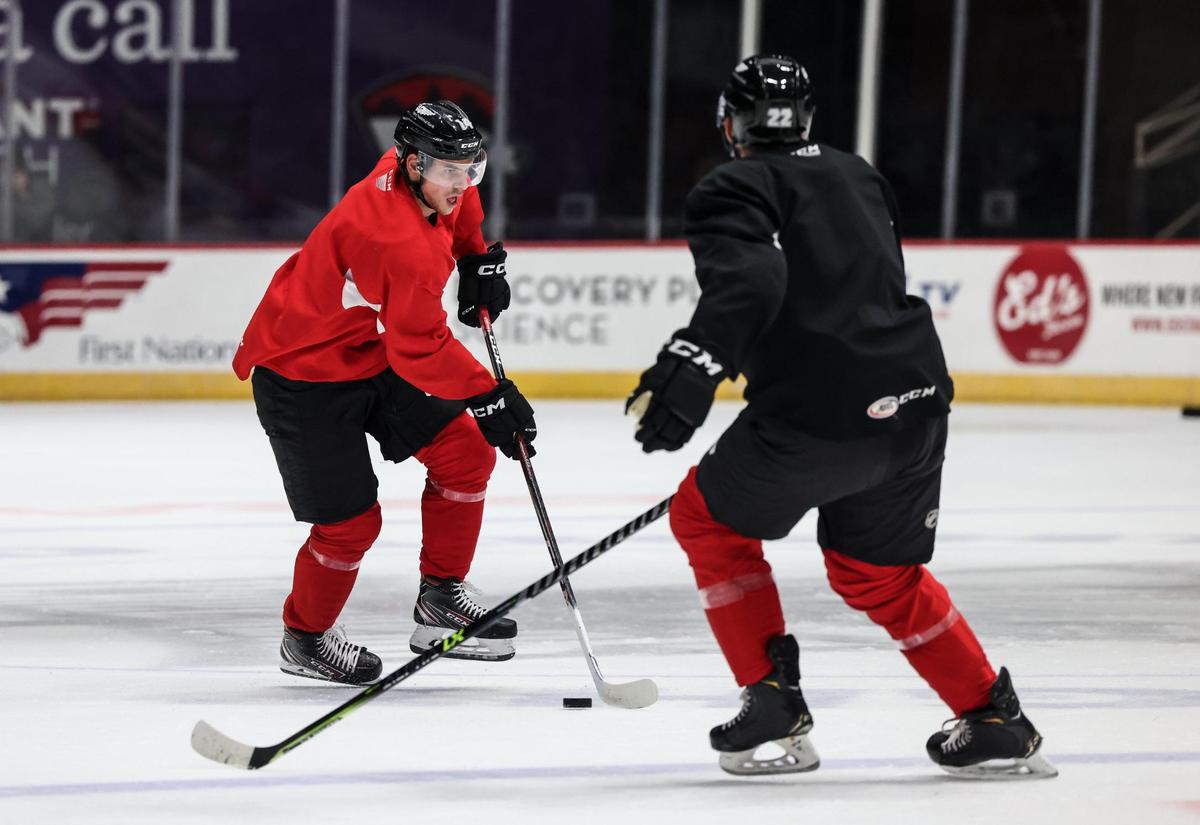 Checkers Grigori Denisenko, left, controls the puck during Charlotte Checkers practice in Charlotte N.C., on Wednesday, October 12, 2022.