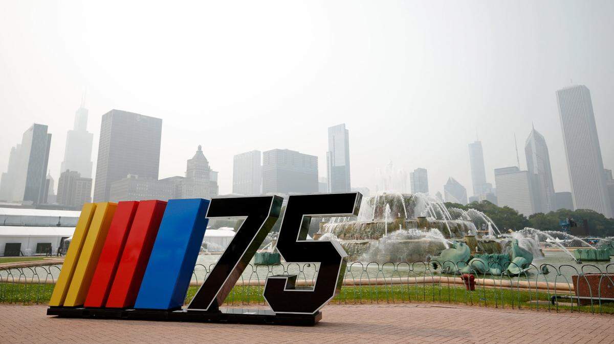 Jun 27, 2023; Chicago, Illinois, USA; A general view of a NASCAR sign next to Buckingham Fountain before the Chicago Street Race as smoke from Canadian wildfires obscures the skyline. Mandatory Credit: Jon Durr-USA TODAY Sports