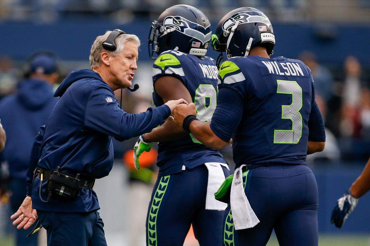 Seattle Seahawks head coach Pete Carroll greets quarterback Russell Wilson following a fourth-quarter touchdown against the Los Angeles Chargers at CenturyLink Field. 